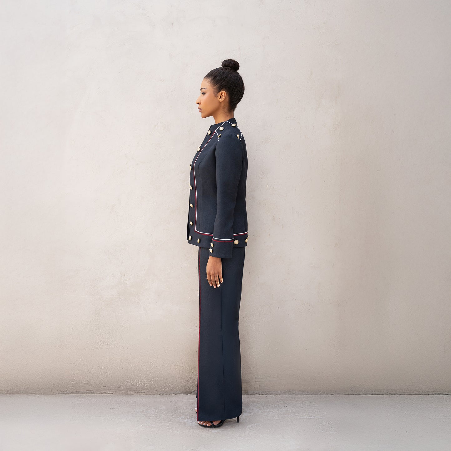 Side profile of the Frame suit, highlighting the clean tailored cut and golden buttons along the jacket.