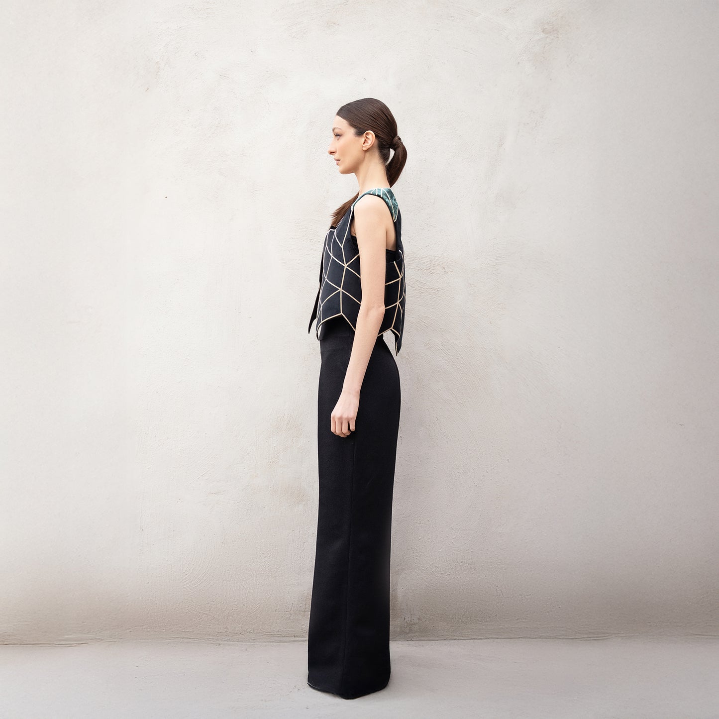 Side profile of the Panther Facad vest, showing the structured silhouette, golden angular design, and green velvet shoulders.