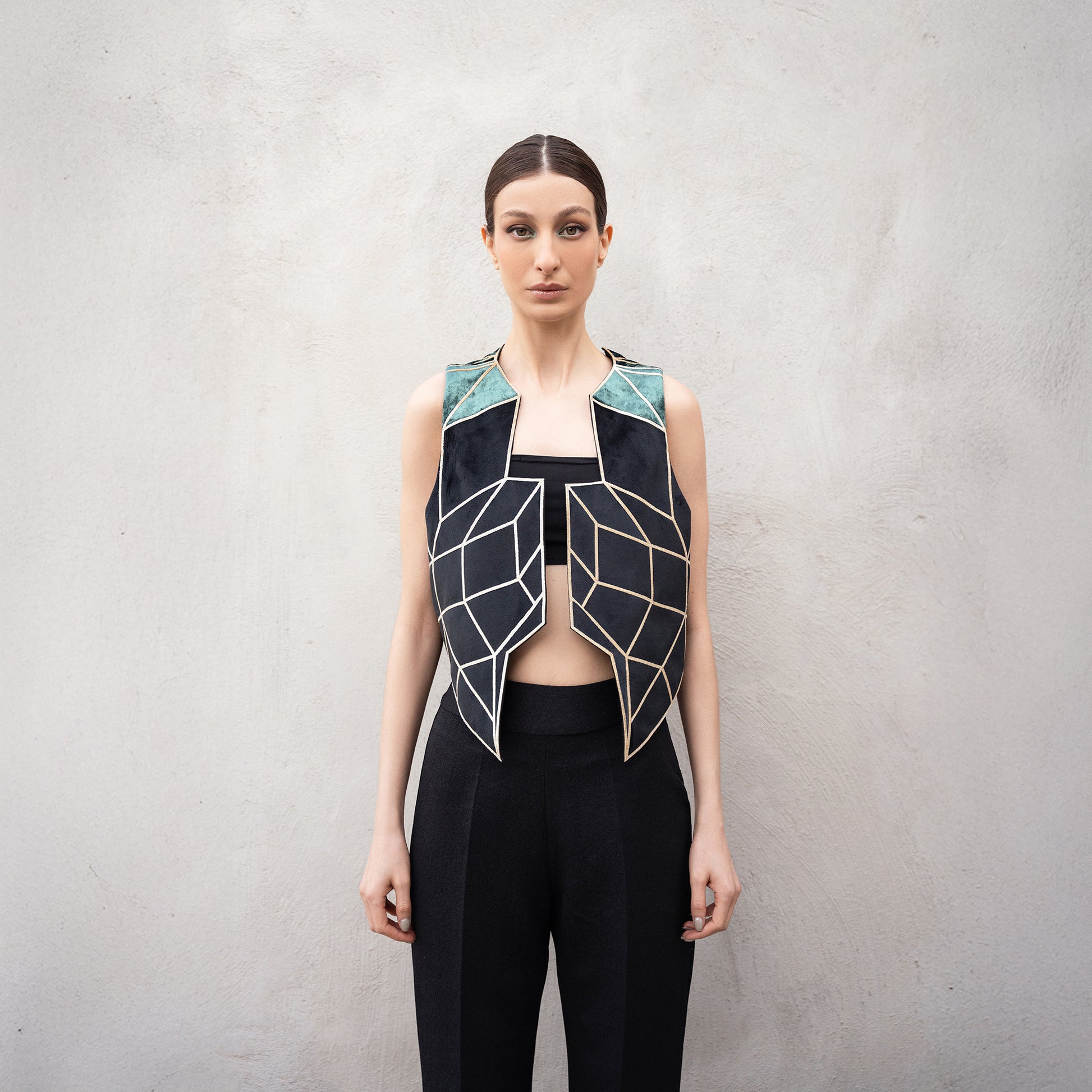 Close-up of the Panther Facad vest, highlighting the golden laser-cut geometric front design and green velvet shoulder panels.