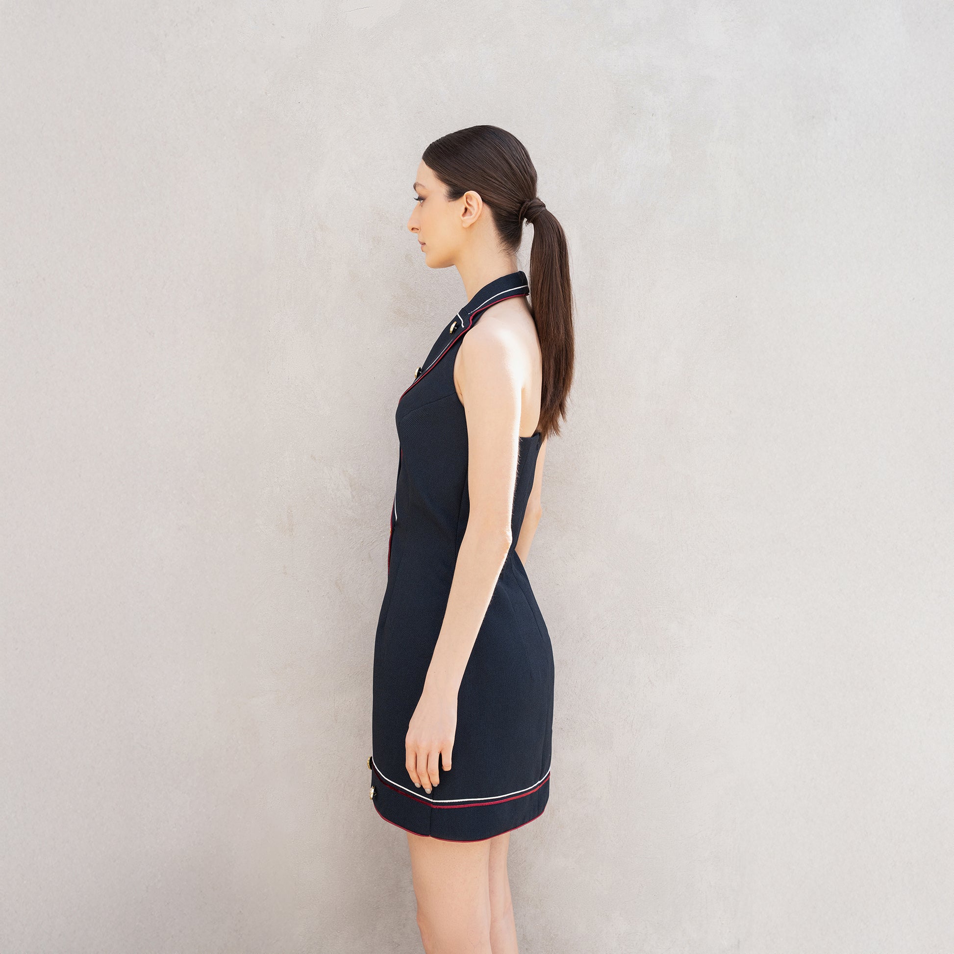 Side profile of the Pulse dress, showing the clean tailored fit and red-and-white line detailing along the hem.